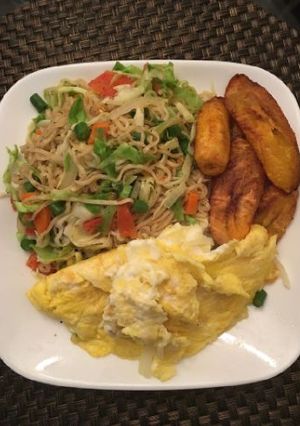 A picture of Indomine with fried plantain,fried egg and vegetables.