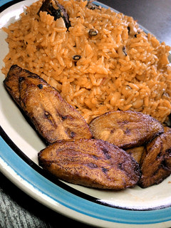 A picture of Jollof rice and beans With fried plantain.