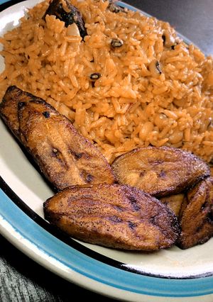 A picture of Jollof rice and beans With fried plantain.