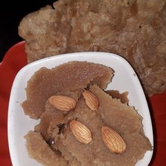 A picture of Suji halwa with poori.