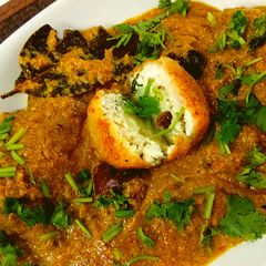 A picture of Aloo kofta with paneer stuffing in golden gravy.