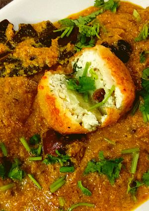 A picture of Aloo kofta with paneer stuffing in golden gravy.