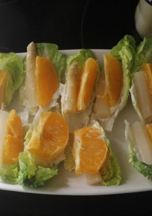 Una foto de Hojas de lechuga con naranja y espárragos