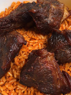 A picture of Jollof rice with fried chicken.