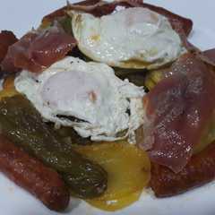 Una foto de Patatas a lo pobre con chistorra jamón y huevos