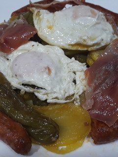Una foto de Patatas a lo pobre con chistorra jamón y huevos