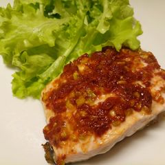 A picture of Salmon fillet with sun-dried tomatoes and pistachio nuts.