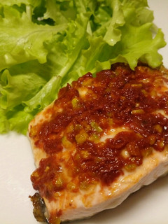 A picture of Salmon fillet with sun-dried tomatoes and pistachio nuts.