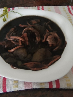 Una foto de Patatas con calamares o pota, en su tinta