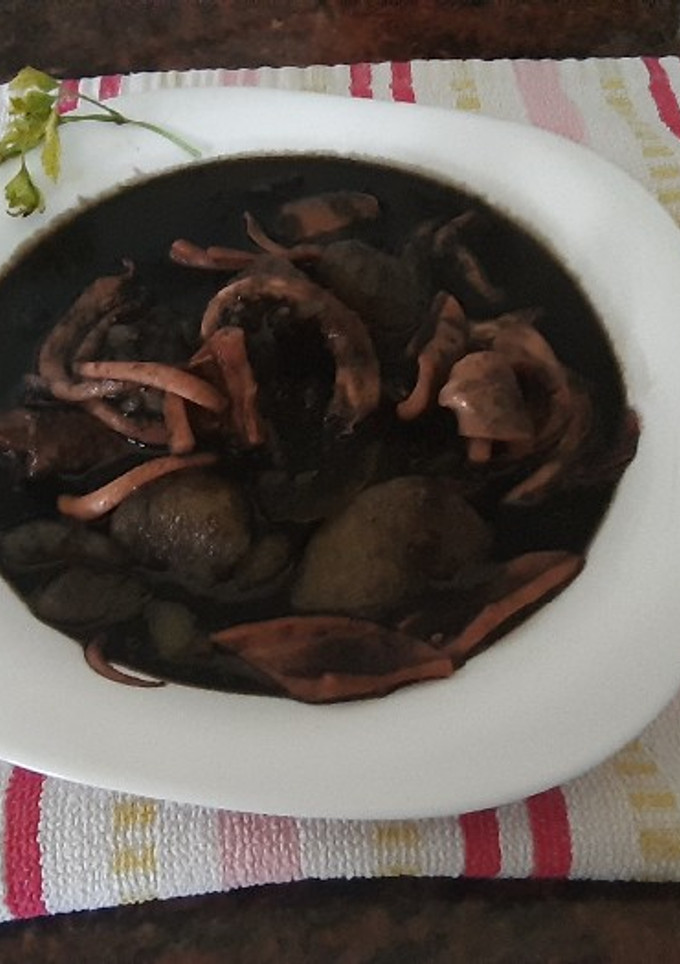 Una foto de Patatas con calamares o pota, en su tinta
