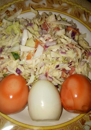A picture of Cabbage and tomatoes salad with coloured eggs.
