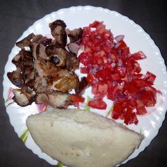 A picture of Oven roasted goat meat with ugali n kachumbari.