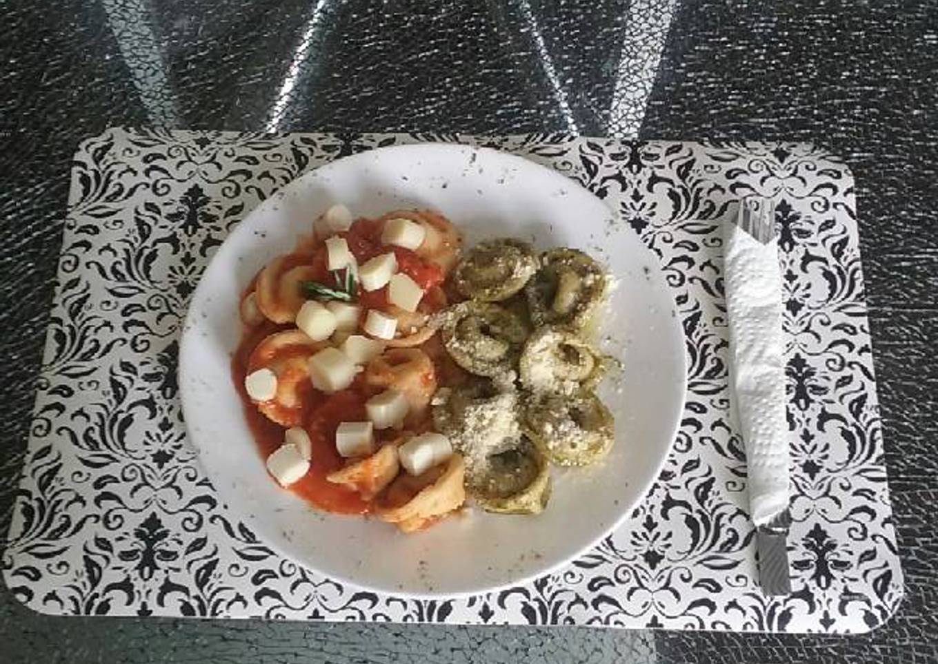 Tortelinis artesanal con carne en salsa napolitana y pesto