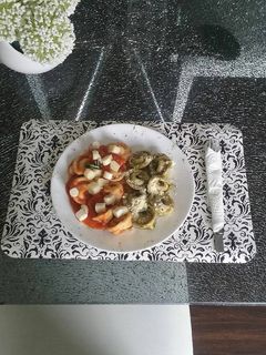 Una foto de Tortelinis artesanal con carne en salsa napolitana y pesto