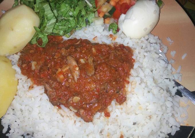 Rice and stew with boiled potatoes,egg and salad