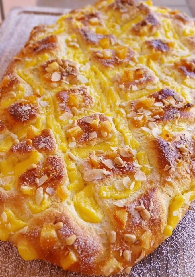 Una foto de Coca de Sant Joan 2024 v2: De crema, naranja confitada, almendras y piñones