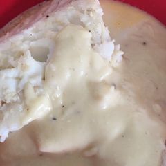 A picture of Poached Cod with white sauce.