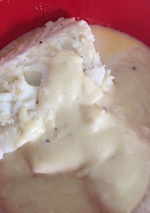A picture of Poached Cod with white sauce.