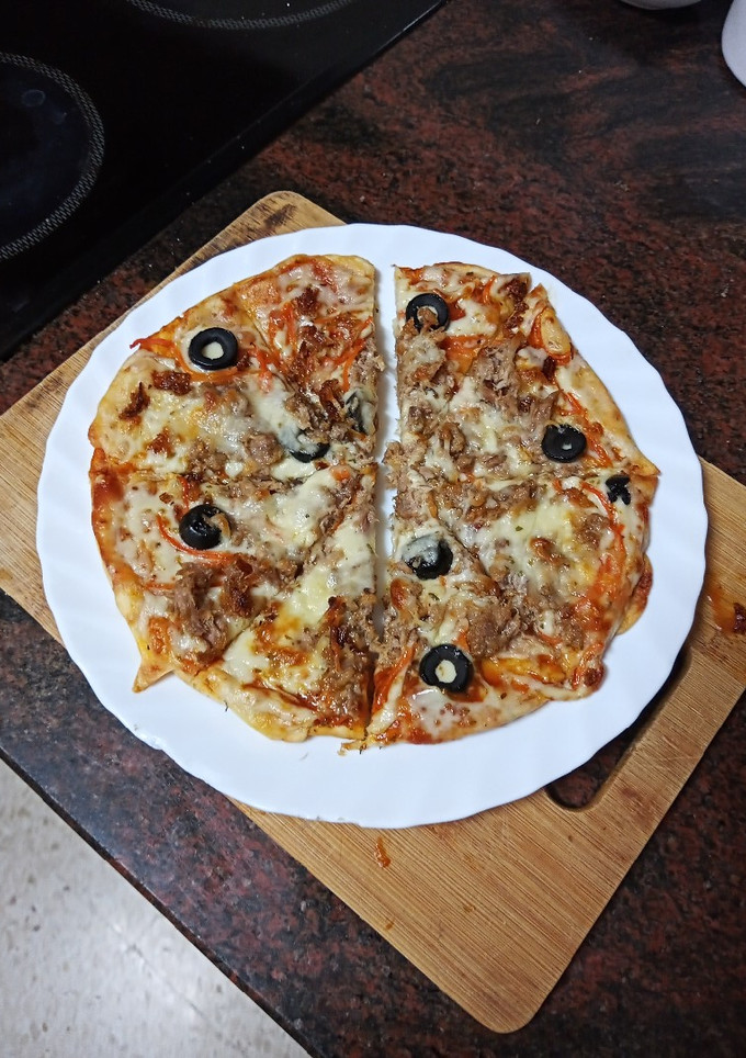Una foto de Pizza de atún con cebolla frita, zanahoria encurtida y olivas