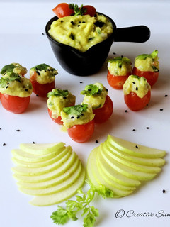 A picture of Cherry tomatoes stuffed with guacamole.