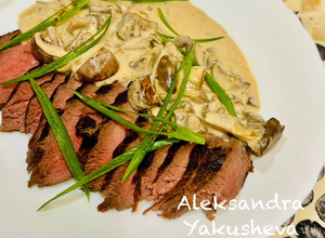 A picture of Ostrich steak with red wine and mushroom sauce.