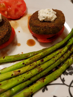 Una foto de Hamburguesas de espinacas y guisantes con trigueros, salsa de queso, y tomate