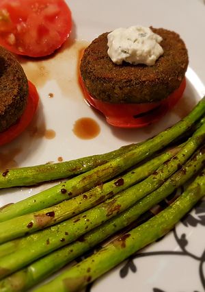 Una foto de Hamburguesas de espinacas y guisantes con trigueros, salsa de queso, y tomate