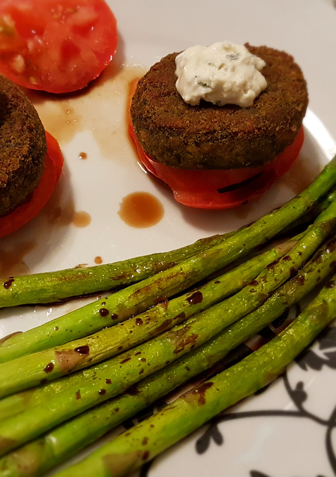 Una foto de Hamburguesas de espinacas y guisantes con trigueros, salsa de queso, y tomate