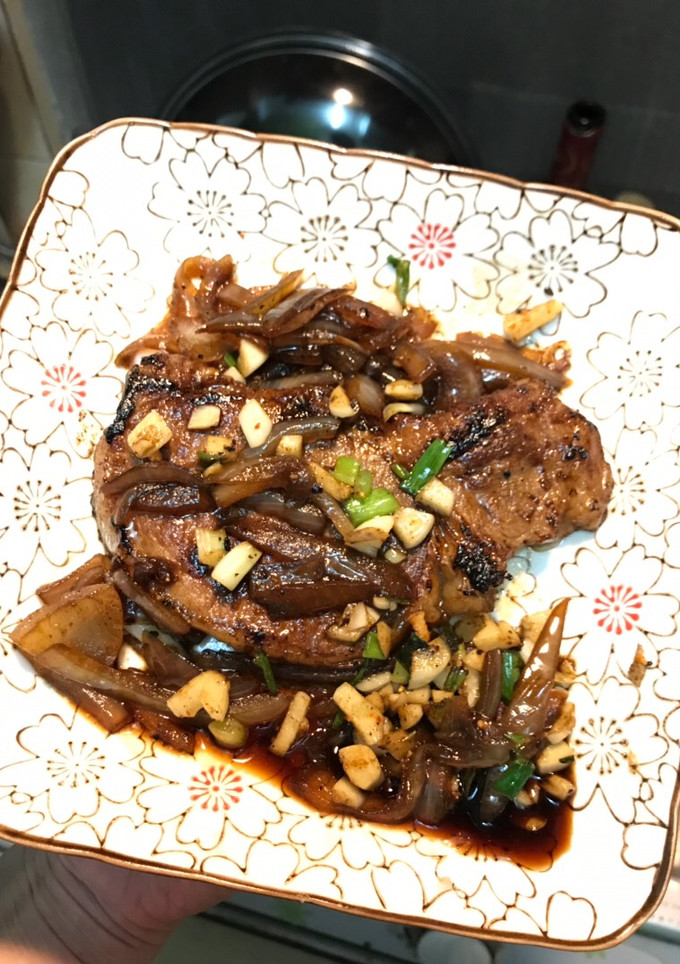 A picture of Pork chop with onion.