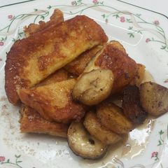 A picture of French Toast with bananas and Maple Syrup.