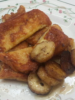 A picture of French Toast with bananas and Maple Syrup.