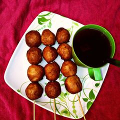 A picture of Black tea with stick puff puff.