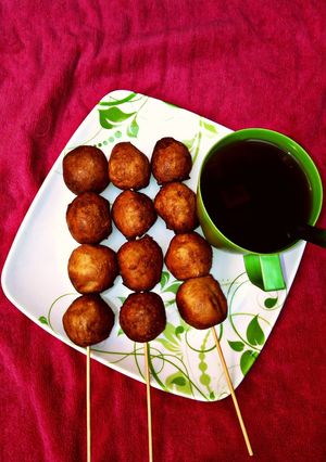 A picture of Black tea with stick puff puff.