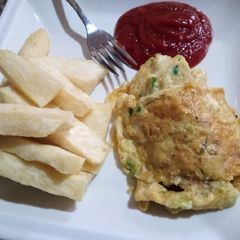 A picture of Fried yam, fried egg and ketchup.