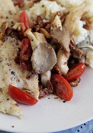 A picture of North Carolina Trout with Sautéed Oyster Mushrooms and Pecans with Gouda Grits.
