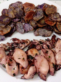Una foto de Chipirones al ajillo y patatas violetas fritas
