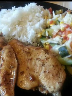 A picture of Grilled chicken with calabasitas and white rice.