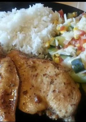 A picture of Grilled chicken with calabasitas and white rice.
