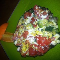 A picture of zucchini tomato feta stuffed portabella.
