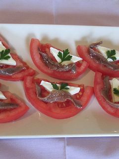 Una foto de Anchoas y queso brie sobre tomates ensaladera