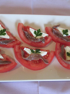 Una foto de Anchoas y queso brie sobre tomates ensaladera