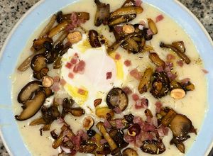Una foto de Crema de coliflor trufada con huevo poché, setas salteadas y jamón