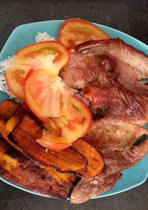 Una foto de Carne de cerdo frita y tajadas de plátano