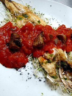 Una foto de Lubina a la plancha con pisto manchego y coronada con boletus