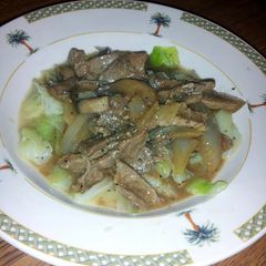 A picture of smothered thin steak over cabbage.