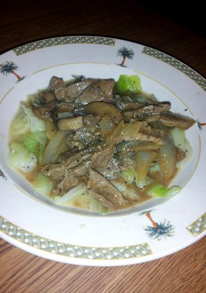 A picture of smothered thin steak over cabbage.