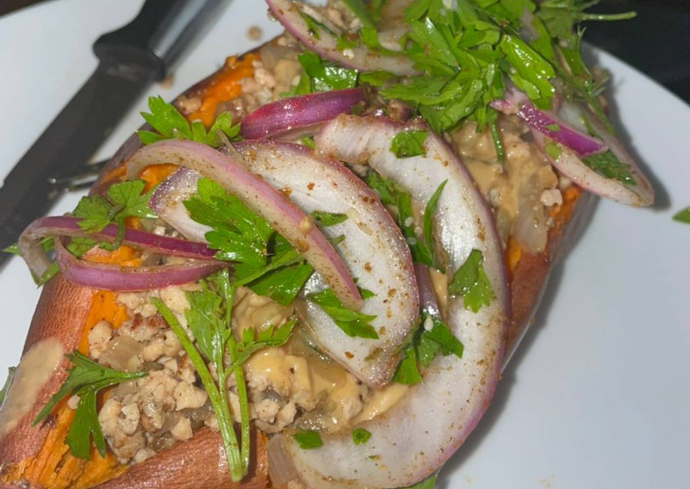 Sweet potato stuffed with spicy beef, tahini salad and parsley