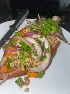 A picture of Sweet Potato stuffed with spiced beef, tahini and parsley salad.