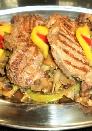 Una foto de Bifes de chorizo con guarnición de puerros y hongos al vino blanco