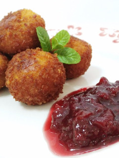 Una foto de Croquetas artesanas de ancas al ajo negro con confitura de cerezas casera